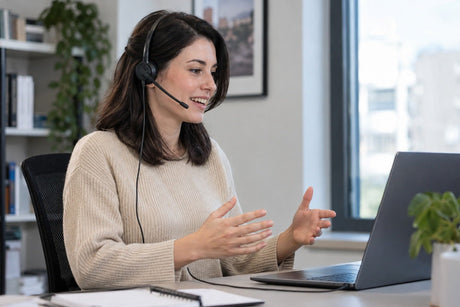 Wired computer headset with boom microphone used for an office call at a fixed workstation