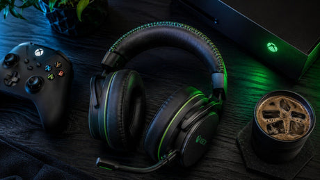 A flat lay image of a premium Bluetooth gaming headset for Xbox with green LED lighting, featuring an Xbox wireless controller nearby, perfect for a blog post about the best Xbox wireless headset options