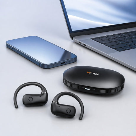 Black Wantek OBT030 open-ear earbuds and charging case beside a smartphone and laptop